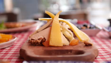 assorted cheeses and nuts on a wooden board