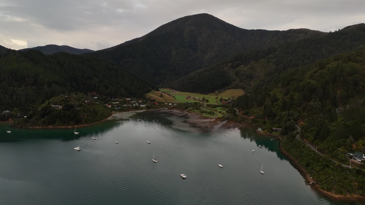 Breathtaking 4K drone footage captures a unique backwards-flying shot over the pristine waters of Whatamango Bay in New Zealand's South Island, revealing the stunning coastal landscape