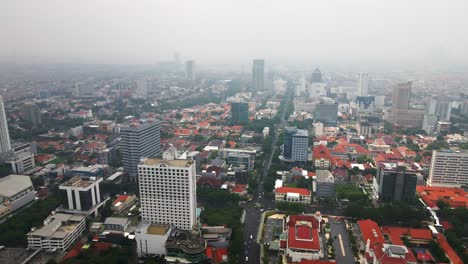 the bustling streets in the heart of surabaya, the second largest city in indonesia, signify rapid economic growth with tall buildings soaring amidst densely populated urban landscape