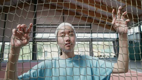 young woman behind tennis net