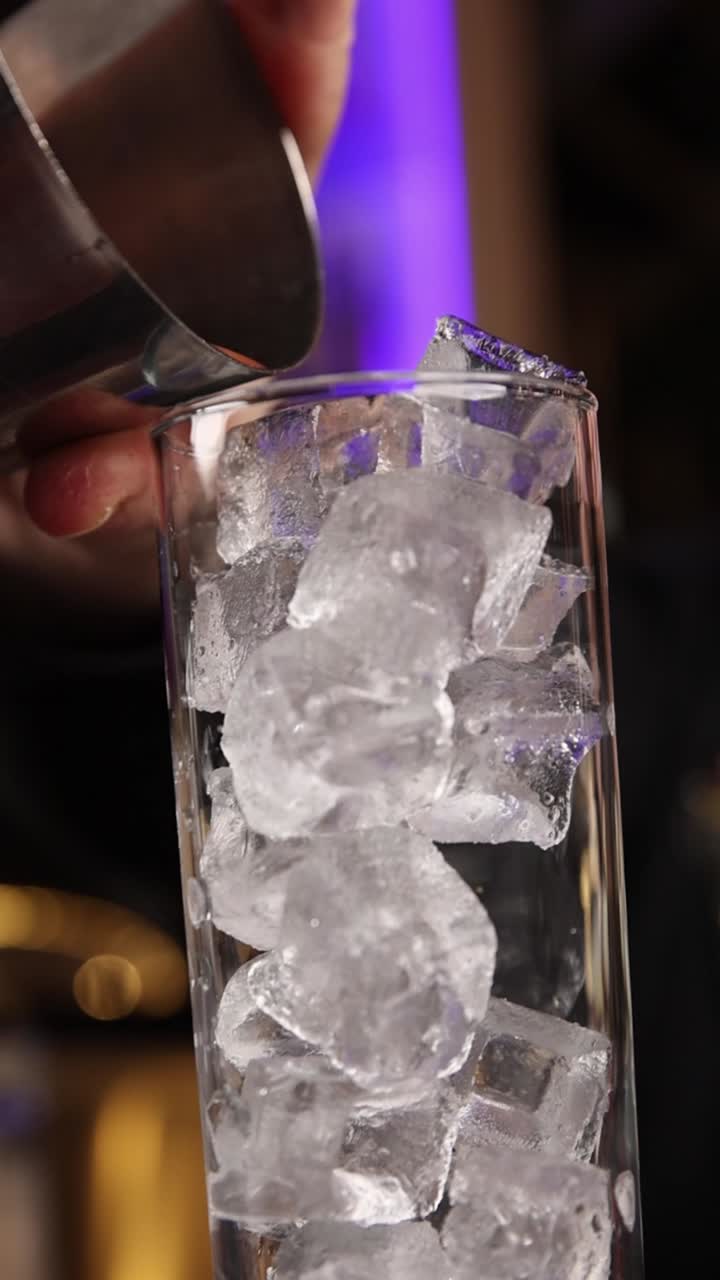 Pouring a cocktail into a glass of ice