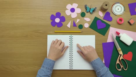 aerial footage of female writing in diary by art equipment