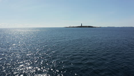 flying low over ocean toward island with lille torungen lighthouse in norway