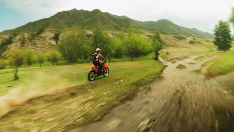 el ciclista en motocicleta cruza el bosque con el arroyo fpv. el motociclista entrenado en un vehículo moderno participa en carreras extremas en rutas fuera de carretera. cabalgando a través de tierras salvajes