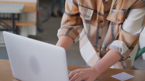 trabajadora o propietaria con computadora portátil comprobando la producción dentro de la bodega