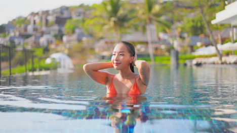 Chica-Modelo-Asiática-Saliendo-De-La-Piscina-Y-Acariciando-Su-Cabello-Mojado