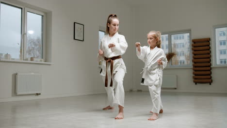 pupil and teacher in white kimono in martial arts class