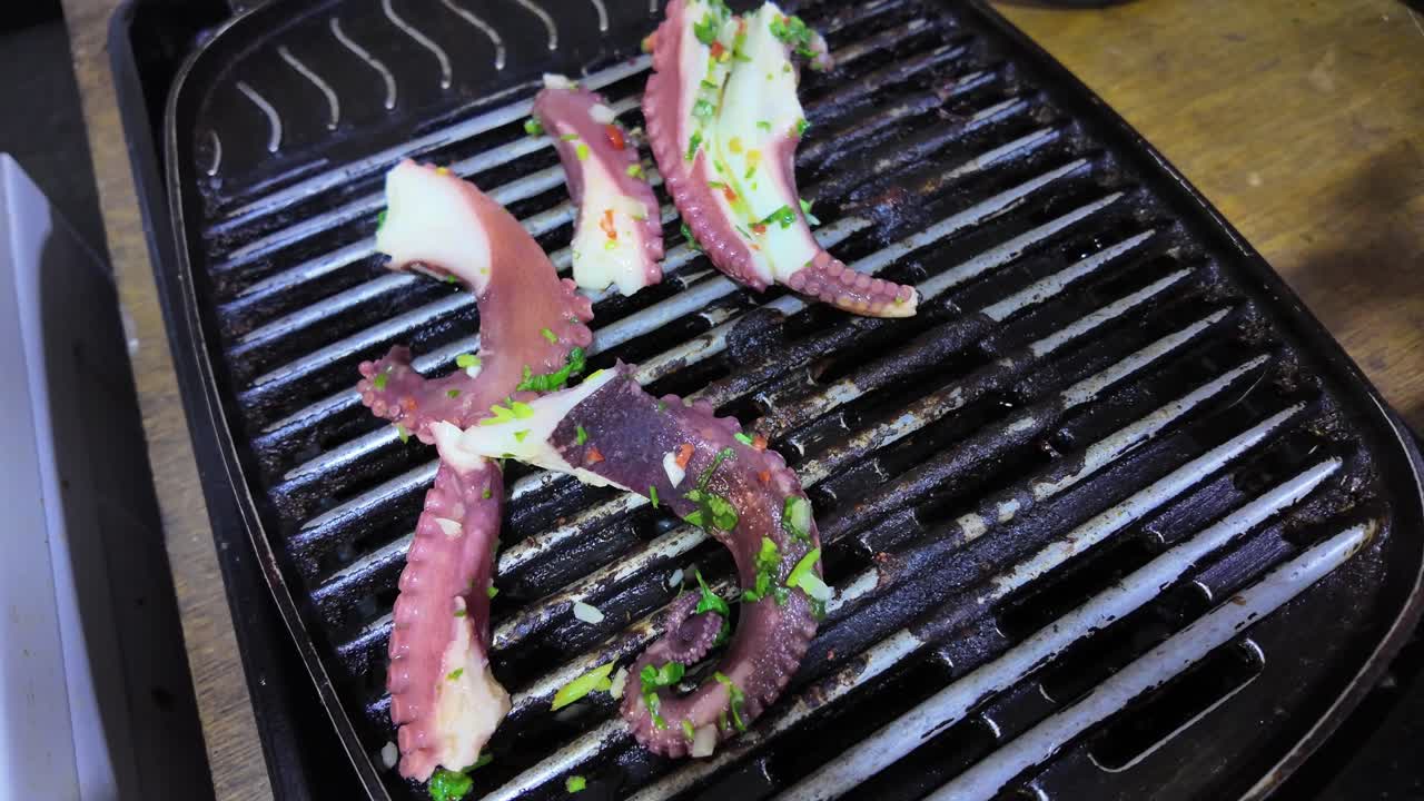 Man hands Flip tentacles while Cooking octopus on a barbecue grill. seafood texture