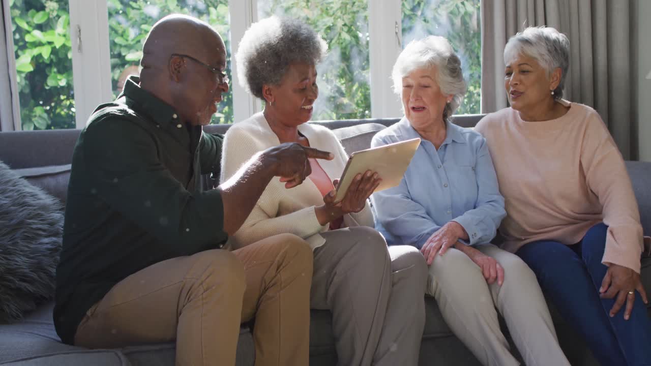 Group of diverse senior people using digital tablet together at home