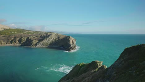 4K-Cinematic-landscape-shot-of-the-beach-of-Lulworth-Cove,-Dorset-on-a-sunny-day