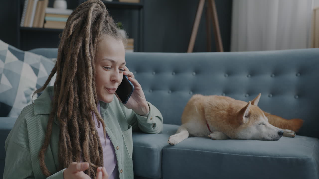 Woman Talking on Phone While Dog Sleeps on Couch