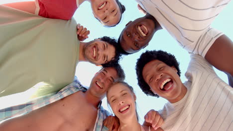 diverse group of friends smile in a huddle outdoors