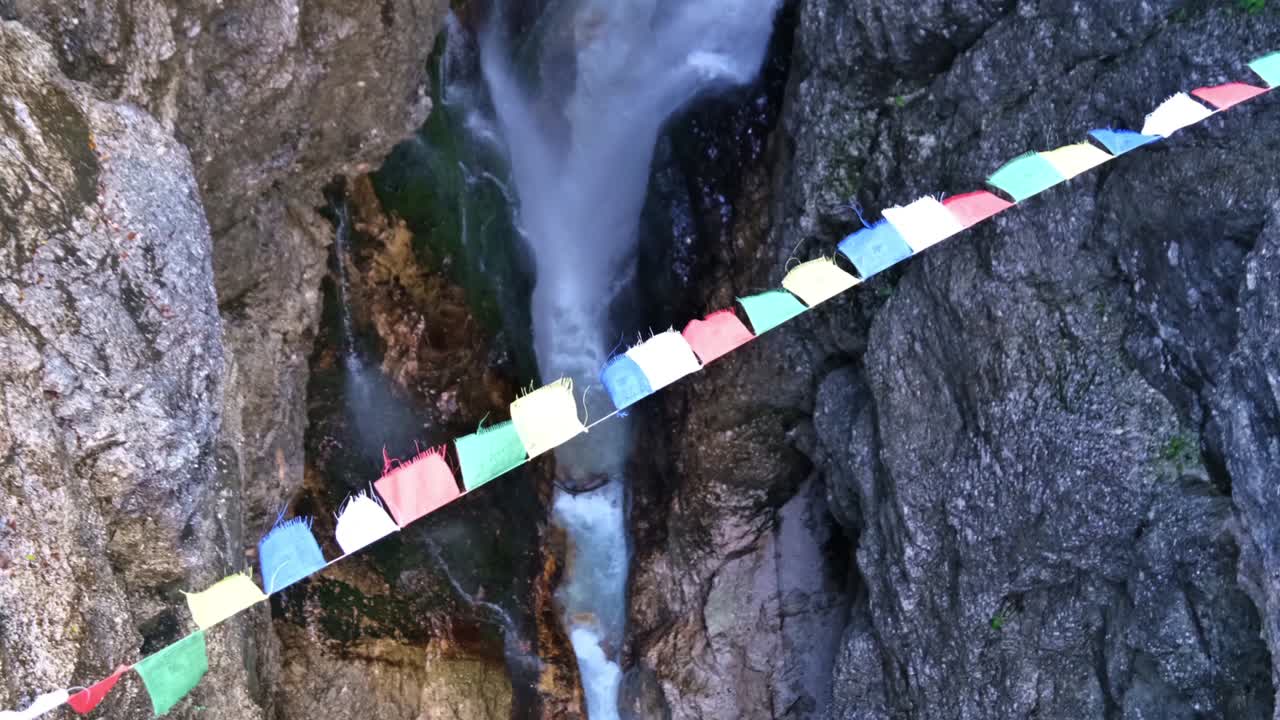 vista de arriba hacia abajo en el desfiladero alemán höllentalklamm con banderas de oración de nepal tensas sobre el poderoso arroyo del cañón, ondeando en el viento