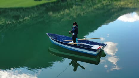 la mujer en el barco atrapa un pez en el giro en noruega.