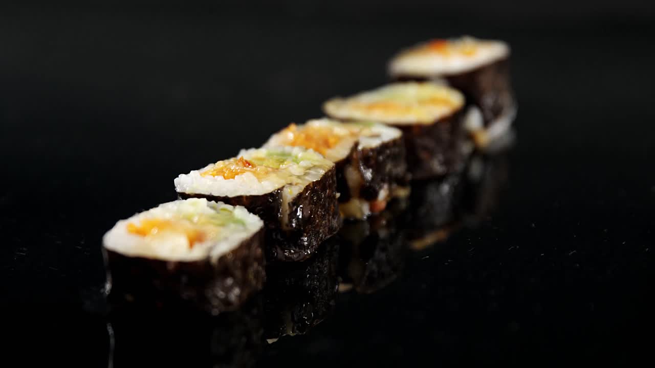 rolo de sushi maki servido em prato de pedra preta