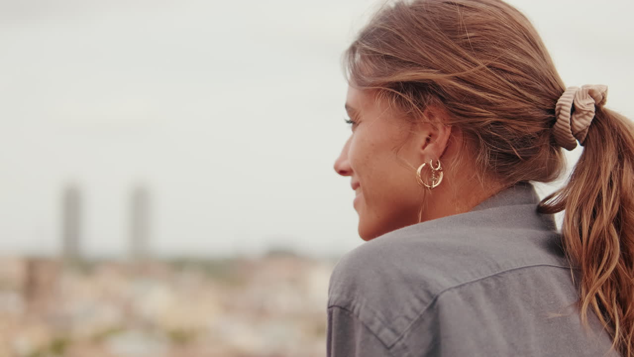 Giovane donna felice che sorride all'aperto con vista sulla città