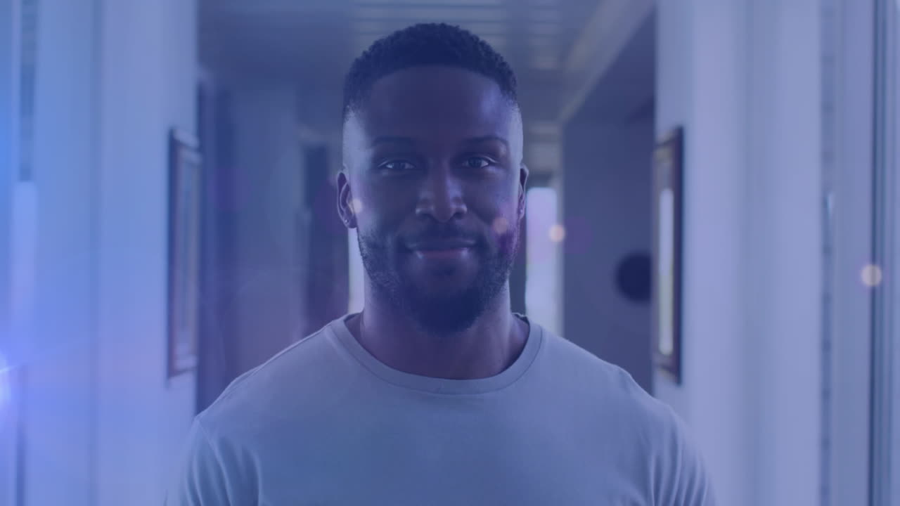 Animazione di luci su un uomo afroamericano felice che guarda in camera