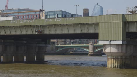 Vista-Desde-El-Barco-Sobre-El-Río-Támesis-Pasando-Por-Debajo-Del-Puente-Ferroviario-De-Cannon-Street-En-La-Ciudad-De-Londres