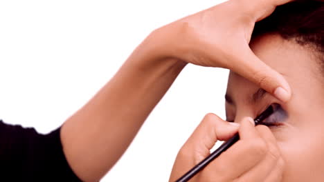 artista de maquillaje poniendo sombra de ojos en la cara de los modelos