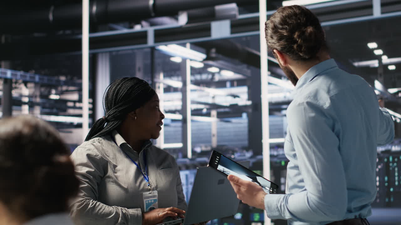 Vertical video Data scientists working together in server room, reviewing neural network code