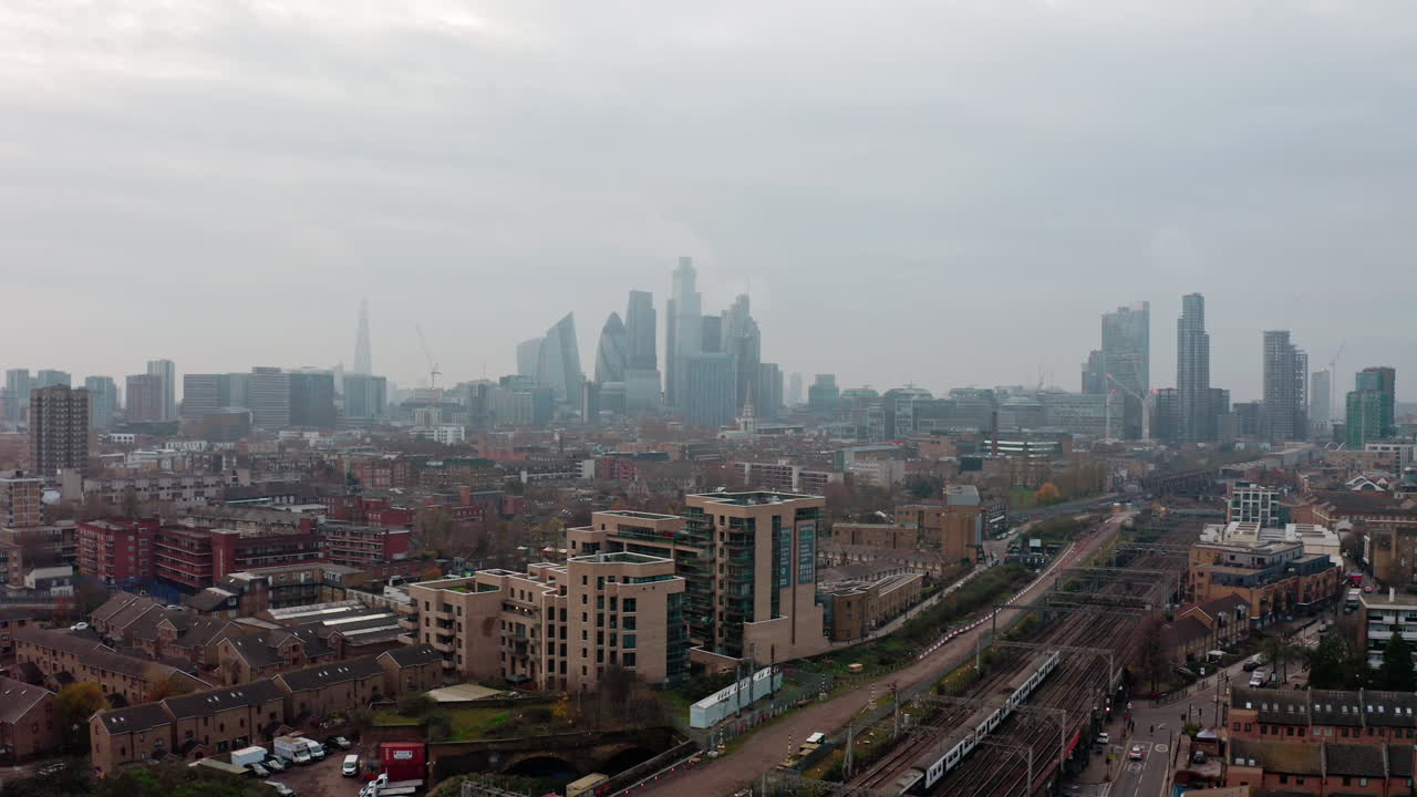 전경에서 지상 열차가 지나가는 런던 시내 스카이라인의 슬라이더 드론 샷