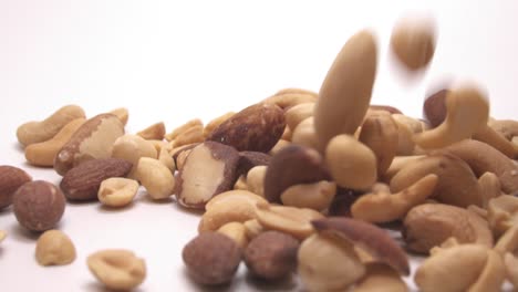 Close-Up-Of-Mixed-Nuts-Falling-Against-White-Background