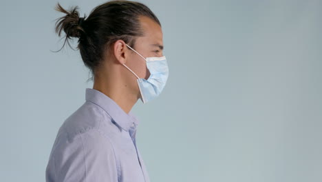 right side shot of man putting on hygienic mask