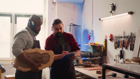 fabricante y aprendiz leyendo esquemas de montaje de muebles en el estudio