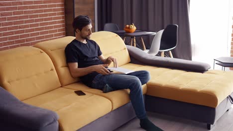 hombre de cabello oscuro trabajando en una computadora portátil en casa