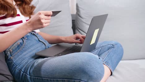 manos de una mujer que usa una tarjeta de crédito para comprar en línea en computadoras portátiles en casa en una situación de covid-19