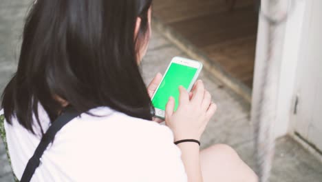 woman using smartphone on a swing