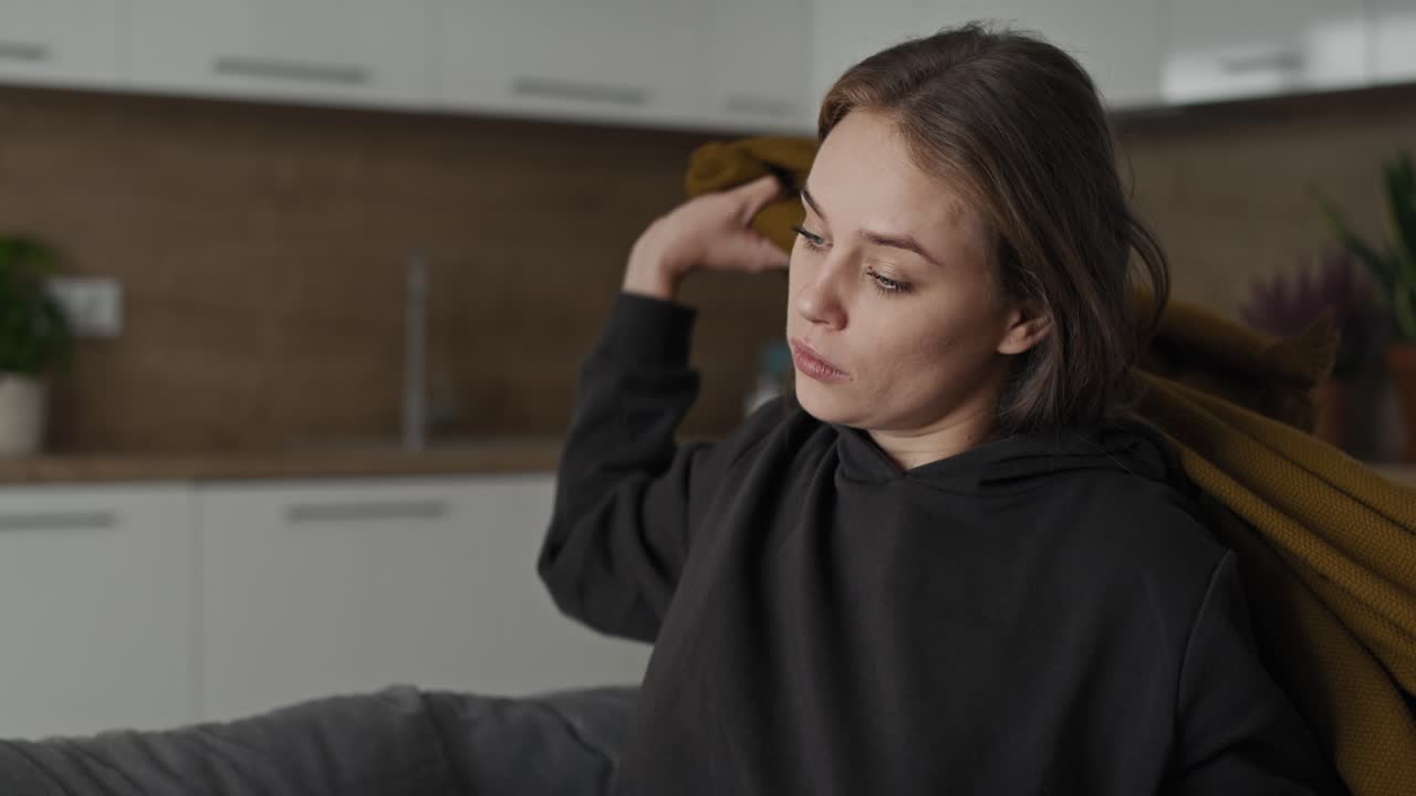 Caucasian sad woman covering the blanket at home.