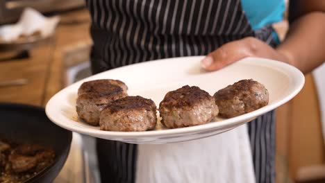 Taking-spiced-lamb-patties-out-of-the-frying-pan-and-onto-a-plate-for-serving---LAMB-PATTY-SERIES