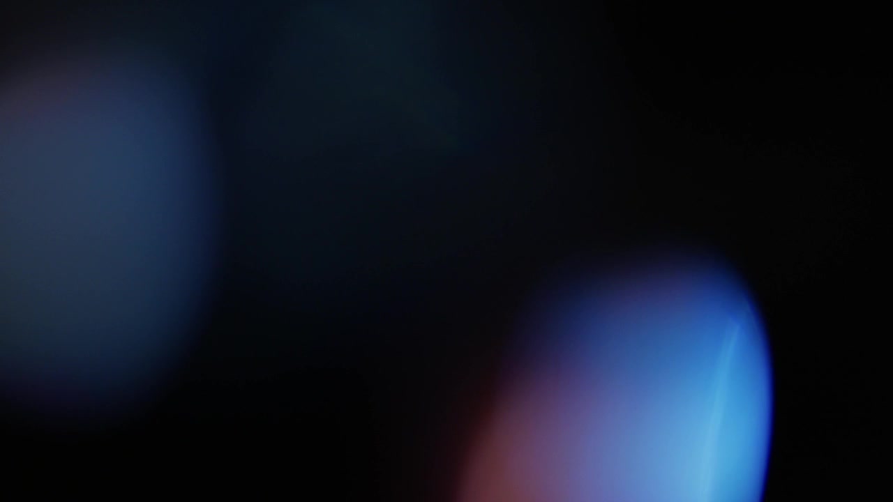 Abstrakt bevægende lyslækager og lens flares på sort baggrund