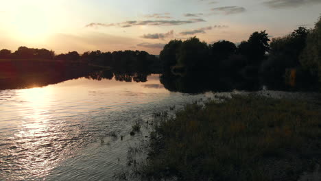 slow low aerial camera footage rising up over the river wye at sunset in summer