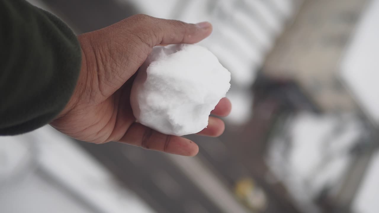 Hand holding a snowball in winter