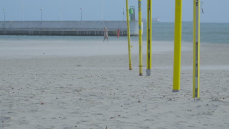 A-person-walks-along-the-seashore-during-a-sandstorm