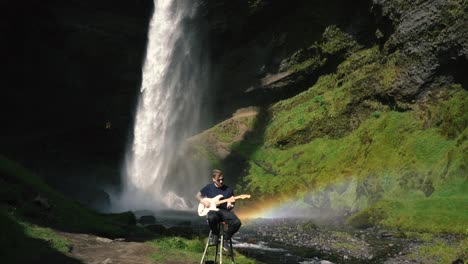 Man-playing-guitar-in-front-of-a-beautiful-waterfall-in-Iceland-21