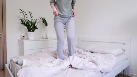 mujer en pijama saltando en la cama. hermosa habitación brillante en un estilo moderno