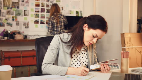 woman, designer and writing notes for color swatch