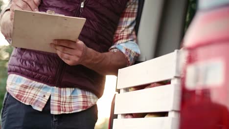 handheld view of experienced farmer examining some data from clipboard