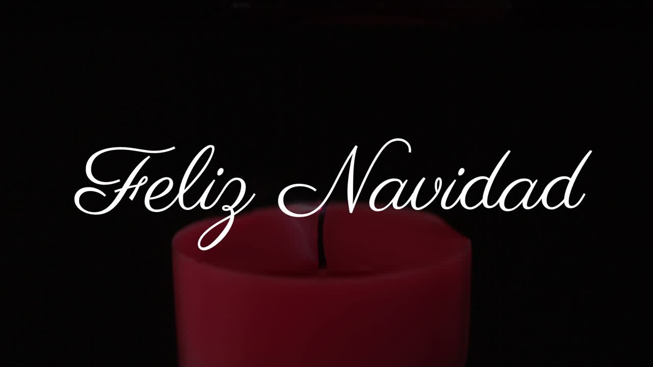 Feliz Navidad text animation over burning red candle in dark background