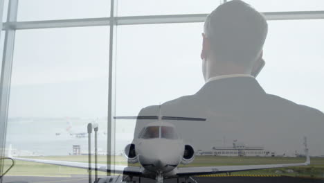 hombre de negocios hablando por teléfono, animación de avión sobre el fondo de la terminal del aeropuerto