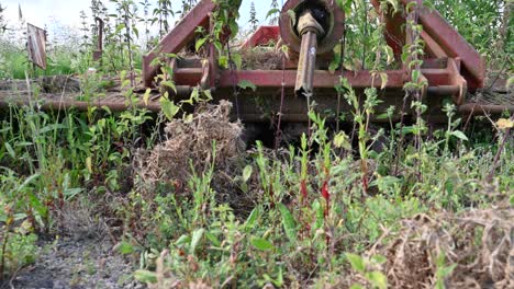 old farm equipment overgrown and lying abandoned