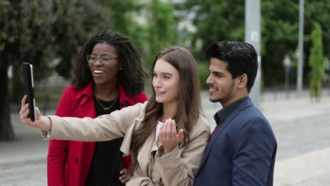 Three-young-people-having-video-chat-on-tablet-outside