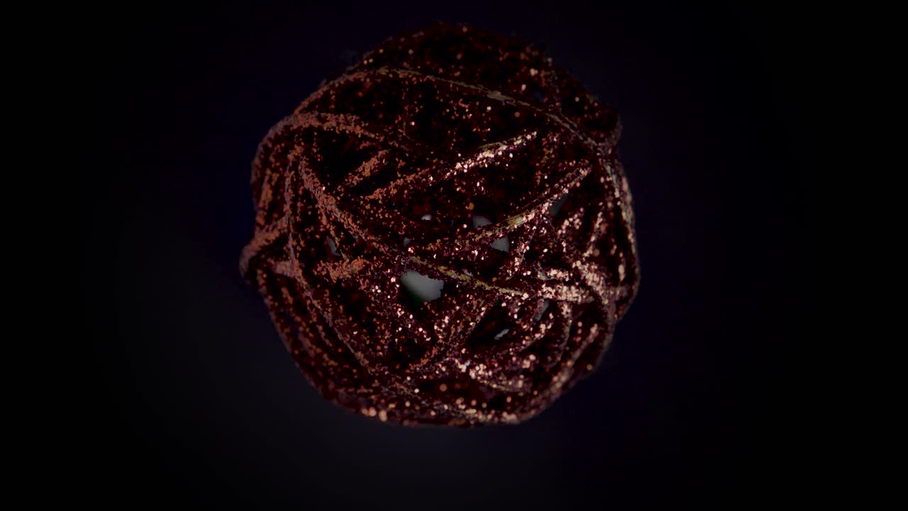 close up static shot of a spinning christmas ball in dark red with glitter