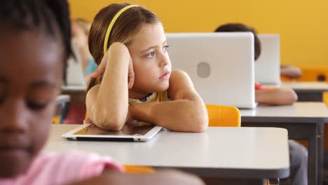 chica aburrida sentada en el escritorio en el aula