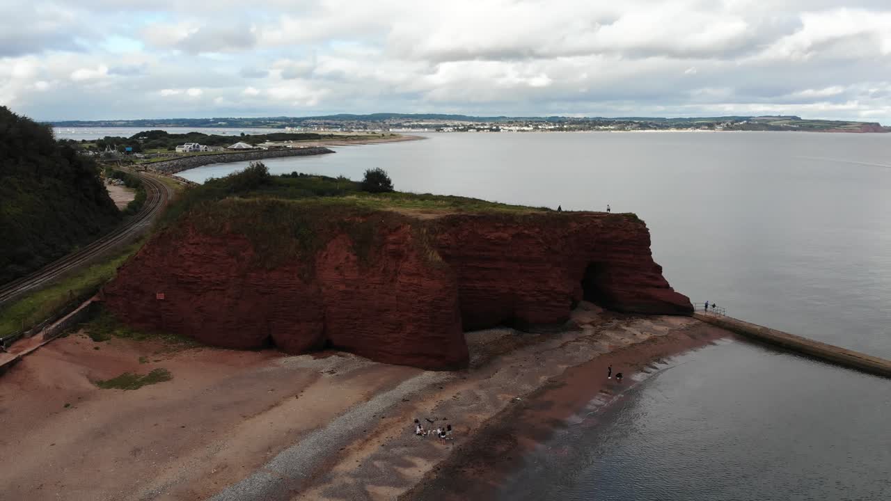 Aerial perspective of Dawlish's coastline featuring prominent red sandstone formations. Rising Shot