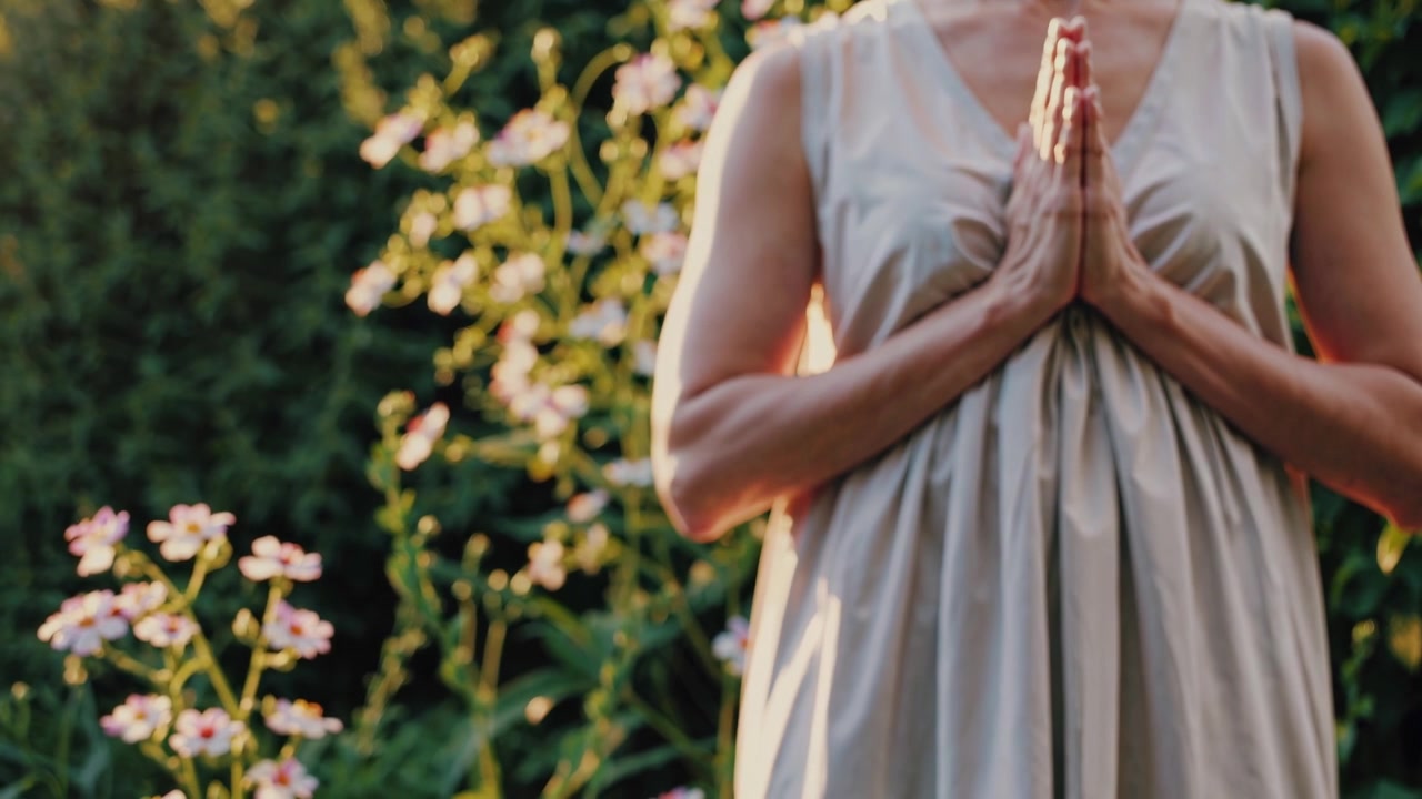 Frau praktiziert Yoga und Meditation in einem Garten