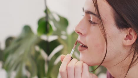 mujer transgénero caucásica no binaria haciendo maquillaje